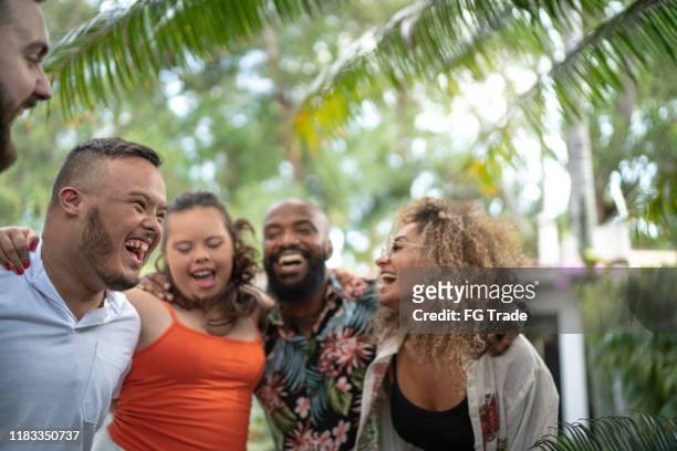 freunde umarmen und singen gemeinsam beim familientreffen - black family reunion stock-fotos und bilder