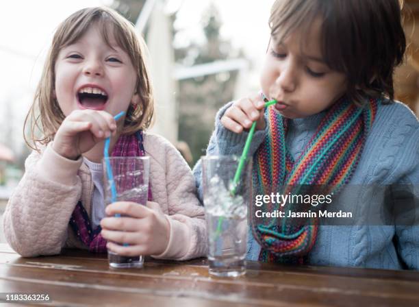 boy and girl blowing water and having fun - familly glasses stockfoto's en -beelden