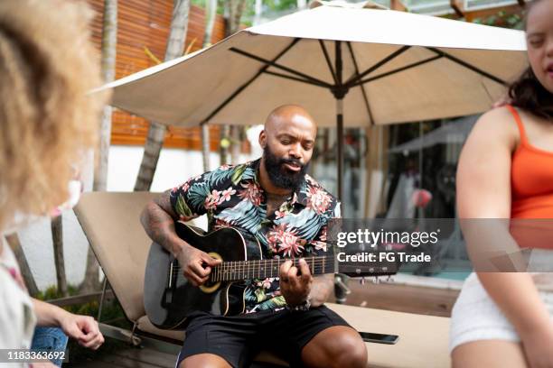 friends / family sitting in backyard singing music - plucking an instrument stock pictures, royalty-free photos & images