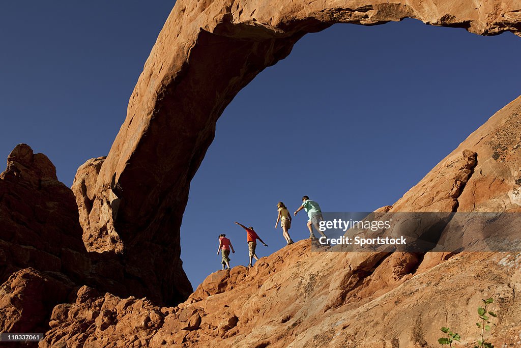 Family of Four Walking On  Rocks In Arches National Park