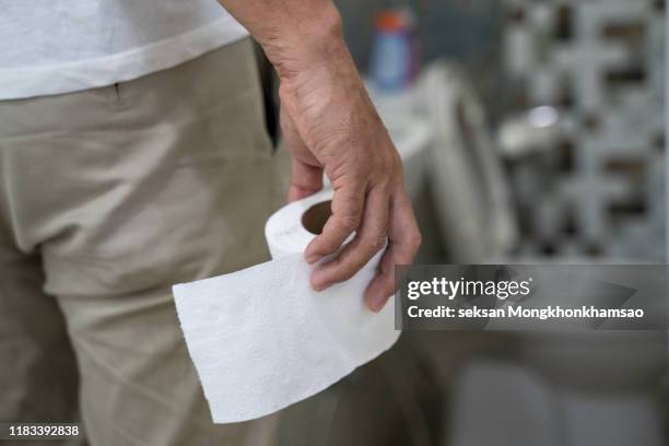 a man with toilet paper in the toilet bowl - diarrhoea foto e immagini stock