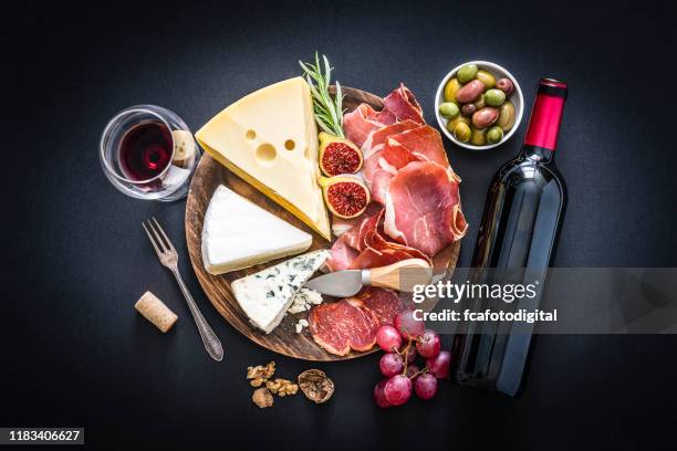 aperitivo: vino tinto, jamón curado y queso sobre fondo negro - queso español fotografías e imágenes de stock