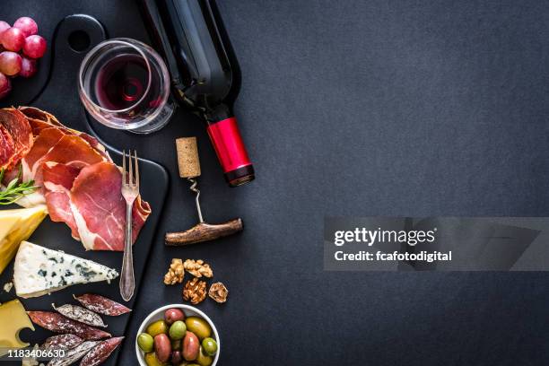 voorgerecht frame: rode wijn, iberico ham en kaas op rustieke tafel - wine bottle from above stockfoto's en -beelden