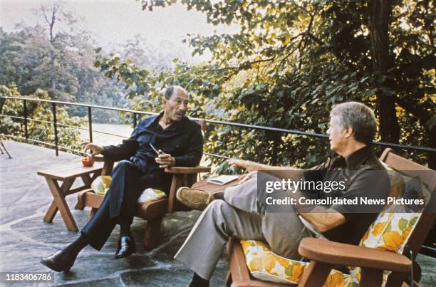 Egyptian President Anwar Al Sadat and US President Jimmy Carter talk together during the Egyptian-Israeli peace negotiations, on the porch of Aspen...