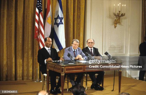 View of, from left, Egyptian President Anwar Al Sadat , US President Jimmy Carter , and Israeli Prime Minister Menachem Begin seated at a table...