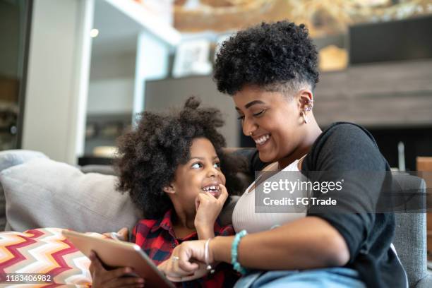 hermanas que usan una tableta digital - familia en casa fotografías e imágenes de stock