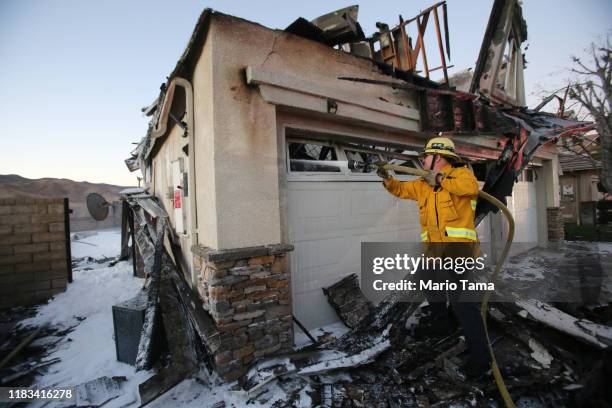 Firefighter works to put out a house fire caused by the Tick Fire on October 25, 2019 in Canyon Country, California. The fire has burned 4,300 acres...