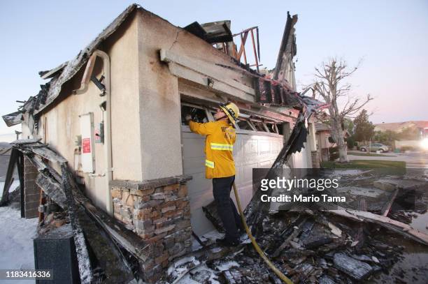 Firefighter works to put out a house fire caused by the Tick Fire on October 25, 2019 in Canyon Country, California. The fire has burned 4,300 acres...