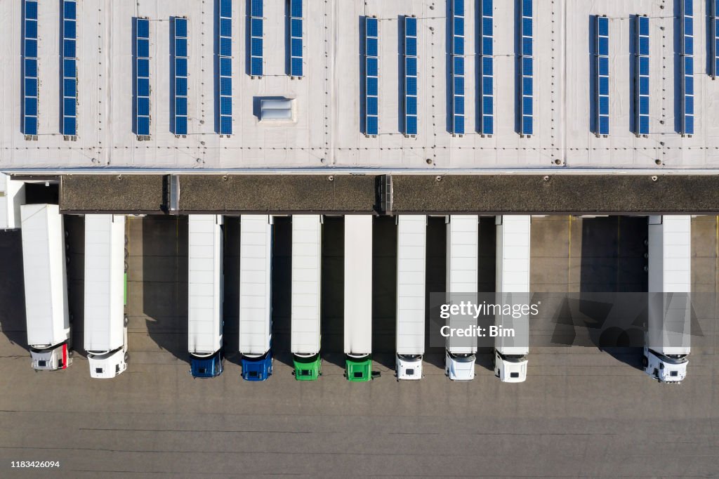 Luftaufnahme von Semi-Trucks Loading im Logistikzentrum, Distributionslager