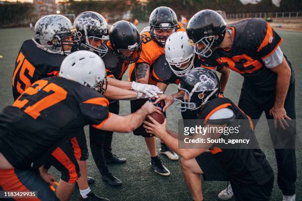 american football players huddling - american football team huddle stock pictures, royalty-free photos & images