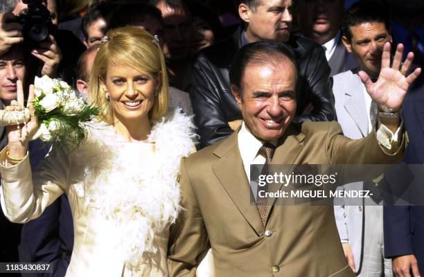 Former Argentine president Carlos Menem and his bride, the Chilean former Miss Universe Cecilia Bolocco wave following their wedding vows in a civil...
