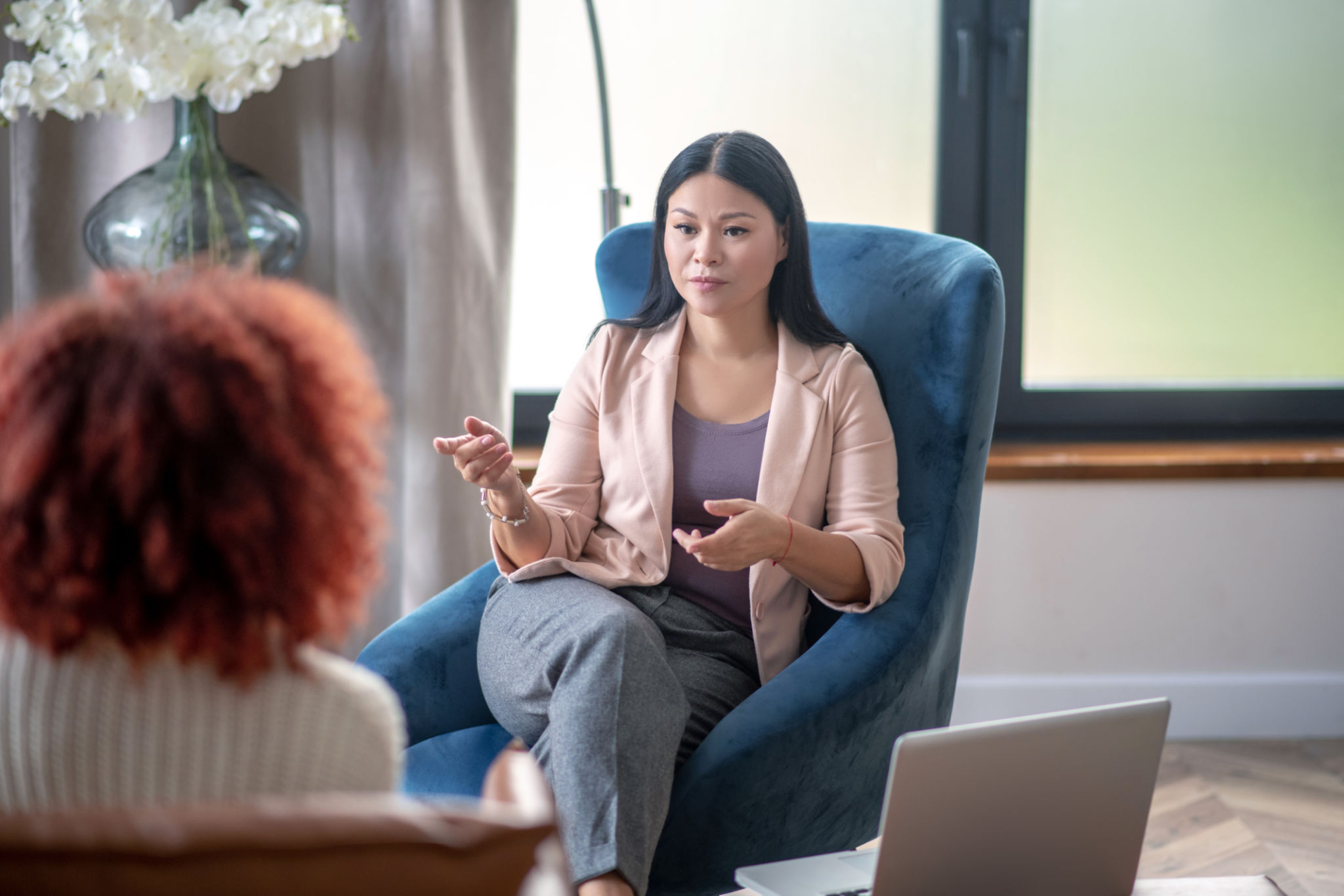 Asian professional female psychologist speaking with client Asian professional female psychologist speaking with client