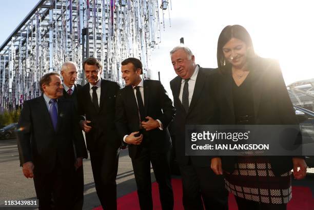 French President Emmanuel Macron is welcomed by AMF vice-president Andre Laignel and president Francois Baroin next to French Senate president Gerard...