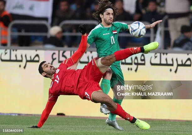 Iraq's midfielder Humam Tariq vies for the ball with Bahrain's defender Abdulla al-Hazaa during the FIFA World Cup 2022 and the 2023 AFC Asian...