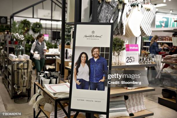 Sign featuring HGTV's Fixer Upper hosts Chip and Joanna Gaines is seen in front of a "Hearth & Hand With Magnolia" display at a Target Corp. Store in...