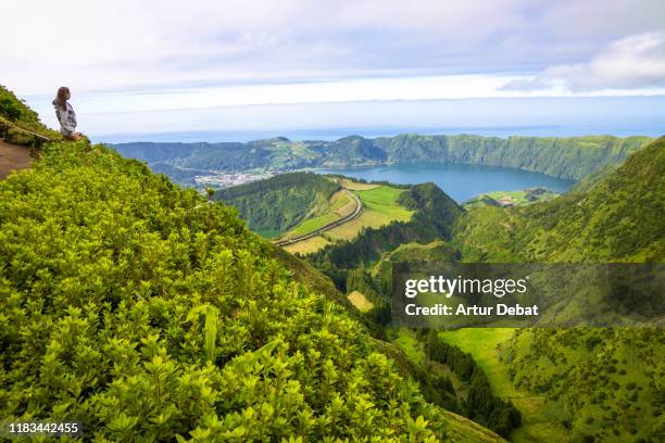 woman on the top of mountain with volcano crater view in the azores. - azores stock pictures, royalty-free photos & images