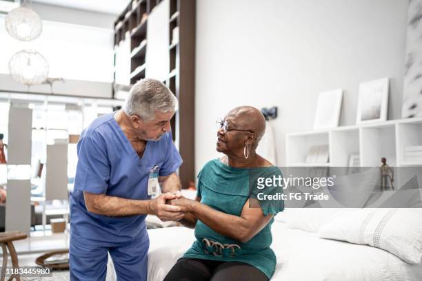doctor consoling a patient, holding hands - optimistic inspiring movement stock pictures, royalty-free photos & images