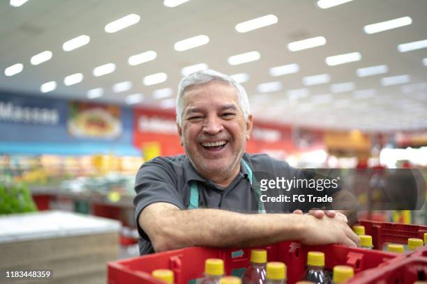 porträt eines lächelnden supermarktangestellten - drink stock-fotos und bilder