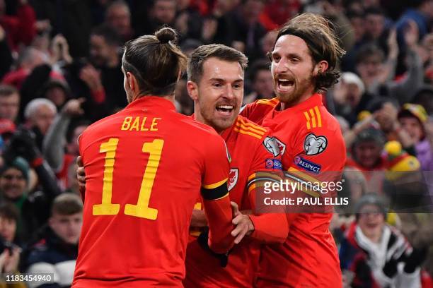 Wales' Aaron Ramsey celebrates with Wales' forward Gareth Bale and Wales' midfielder Joe Allen after scoring his team's first goal during the Group E...