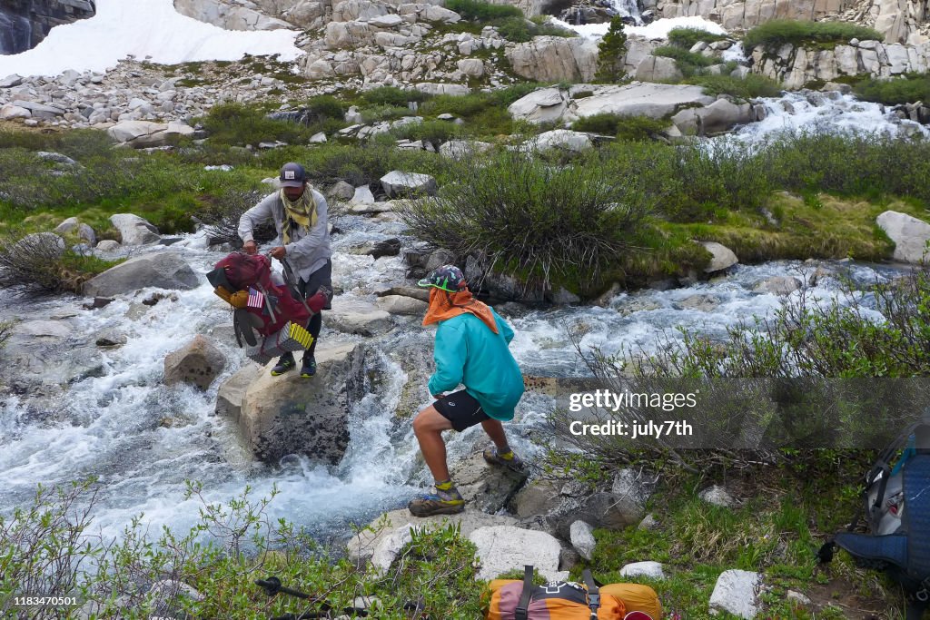 PCT hikers working together to cross the high run stream, John Muir Trail