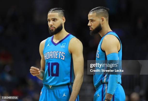 Teammates and brothers Caleb Martin and Cody Martin of the Charlotte Hornets talk during their game against the Minnesota Timberwolves at Spectrum...