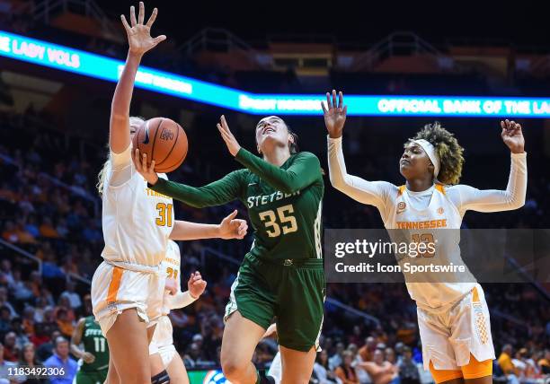 Stetson Hatters forward Kendall Lentz drives between Tennessee Lady Vols center Emily Saunders and guard Jazmine Massengill during a college...