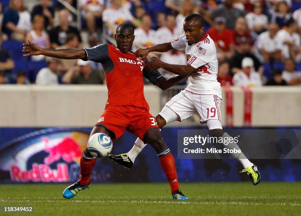 Dane Richards of the New York Red Bulls challenges Tony Tchani of Toronto FC for the ball on July 6, 2011 at Red Bull Arena in Harrison, New Jersey....