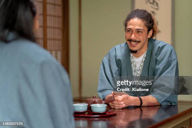young couple of guests at a traditional japanese ryokan (hotel) - washitsu stock pictures, royalty-free photos & images