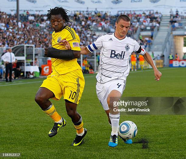 Alain Rochat of the Vancouver Whitecaps FC wins the race to the ball against Andres Mendoza of the Columbus Crew during their MLS game July 6, 2011...
