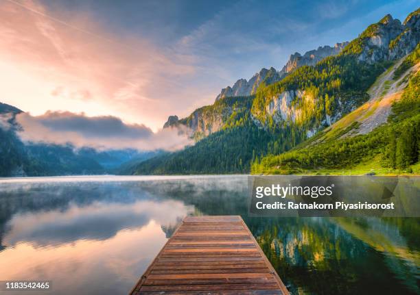 sunrise scene of austrian landscape with forests, fog, meadows, fields and pastures surrounding the lake gosausee with alps mountain - austria stock pictures, royalty-free photos & images