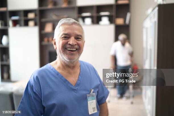 portrait of a senior doctor, patient in the background - african man white background stock pictures, royalty-free photos & images