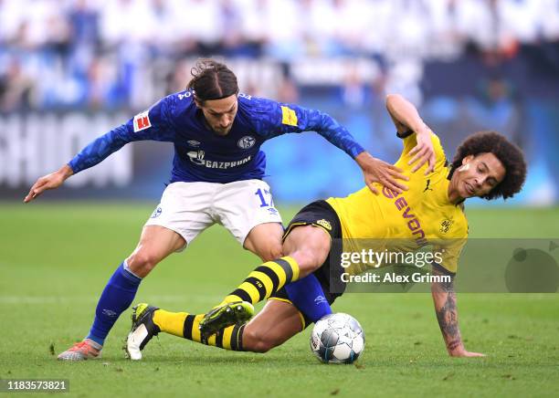 Benjamin Stambouli of FC Schalke 04 battles for possession with Axel Witsel of Borussia Dortmund during the Bundesliga match between FC Schalke 04...