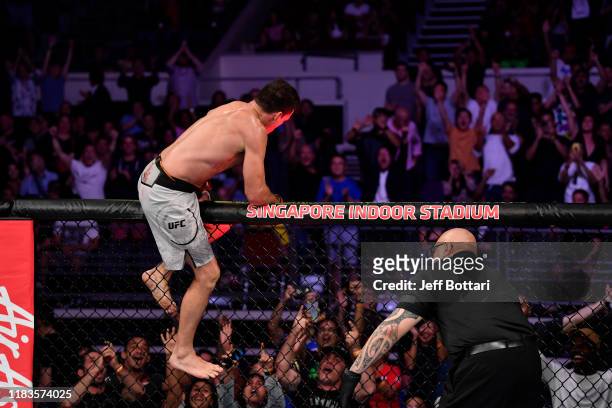Demian Maia of Brazil celebrates his submission victory over Ben Askren in their welterweight bout during the UFC Fight Night event at Singapore...
