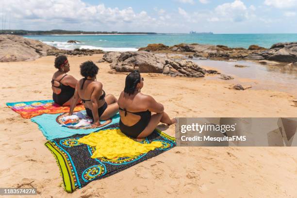 rückansicht von frauen, die im strandsarong sitzen - dicke frauen am strand stock-fotos und bilder