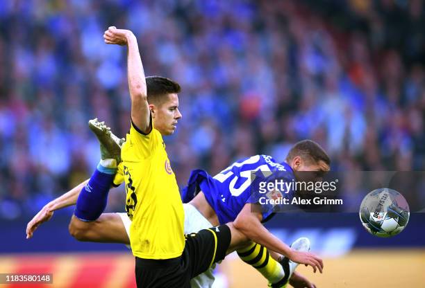 Julian Weigl of Borussia Dortmund collides with Amine Harit of FC Schalke 04 during the Bundesliga match between FC Schalke 04 and Borussia Dortmund...