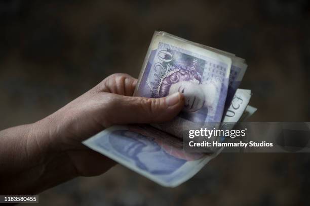 high angle view of an unrecognizable senior adult counting group of british currency pound banknotes - 2017 20 stock pictures, royalty-free photos & images