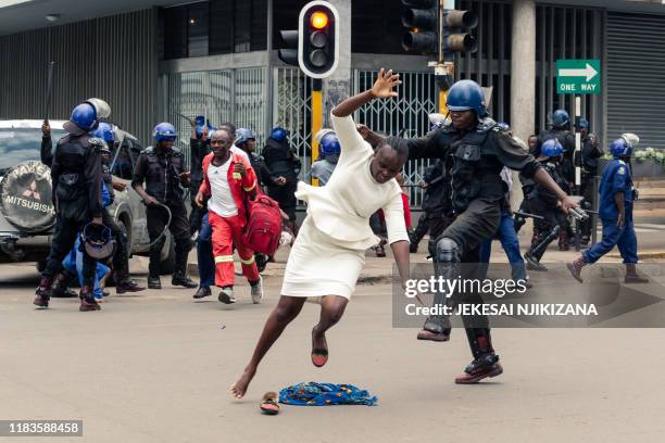 An anti-riot police man in Zimbabwe tackles a woman with his boot as they dispersed a crowd gathered to hear an address by leader of the MDC...