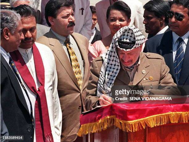 Palestinian Authority President Yasser Arafat signs the visitors book 24 March at the Colombo international airport after his arrival in Sri Lanka...