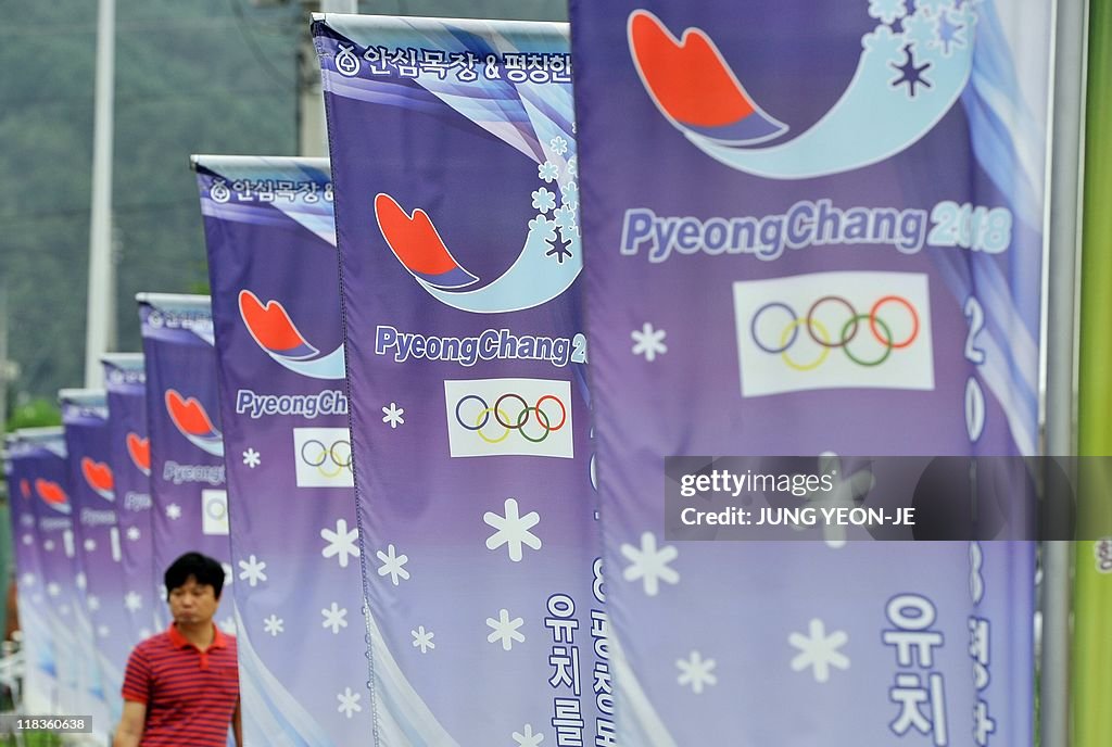 A man walks along a row of banners with