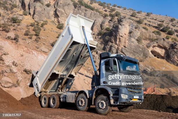 discarica bianca che scarica terreno - dumper truck foto e immagini stock