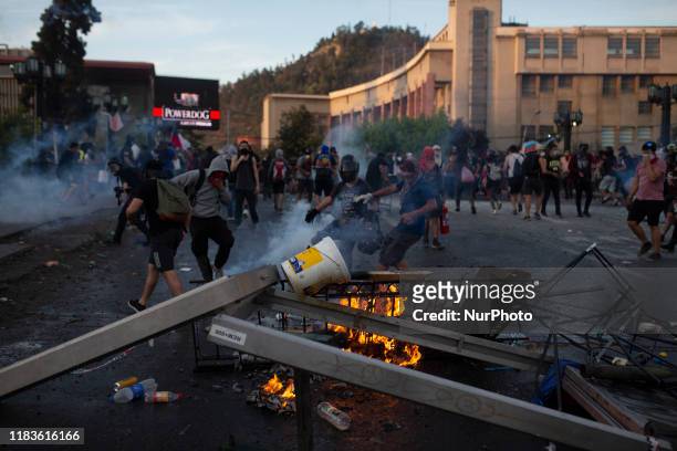 Anti-government demonstrator build a barricade on a street in Santiago during a protest against policies of president Sabastian Pinera. Santiago,...