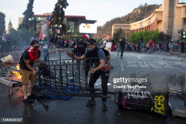 Anti-government demonstrator build a barricade on a street in Santiago during a protest against policies of president Sabastian Pinera. Santiago,...