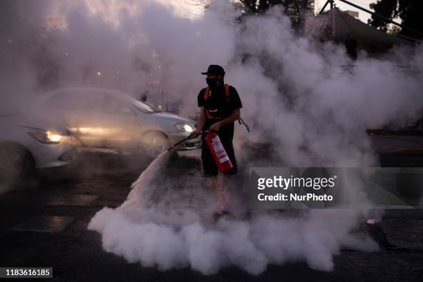 Anti-government demonstrator sprays a fire extinguisher during protest in Santiago, Chile, Ocrober 30, 2019.