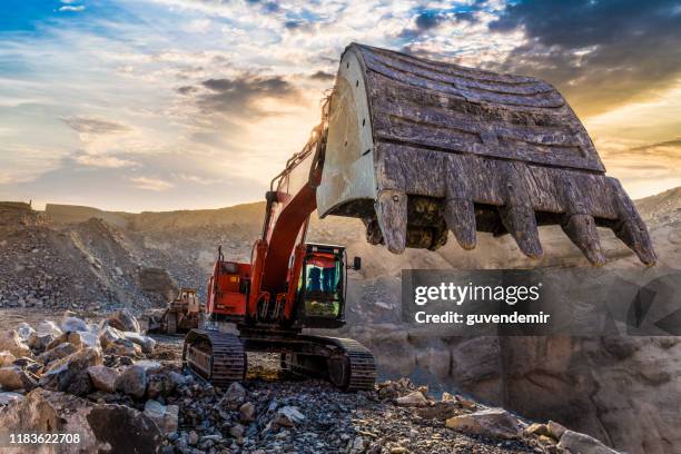 excavadora trabajando en el sitio de minería - máquina excavadora fotografías e imágenes de stock
