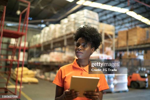 young worker using digital tablet at warehouse - black stock trader stock pictures, royalty-free photos & images