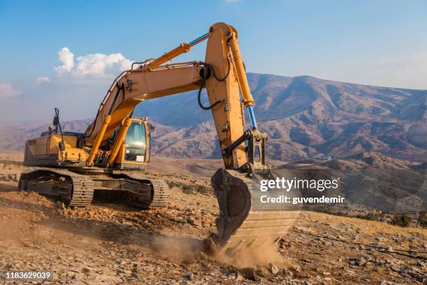 excavator working at construction site on sunny day - excavator bucket stock pictures, royalty-free photos & images