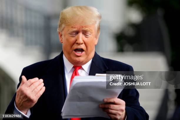 President Donald Trump reads from his notes as he talks to the media on the South Lawn of the White House before boarding Marine One in Washington,...