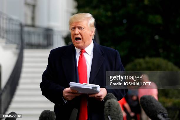 President Donald Trump reads from his notes as he talks to the media on the South Lawn of the White House before boarding Marine One in Washington,...
