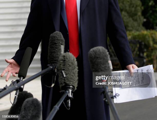 President Donald Trump reads from his notes as he talks to the media on the South Lawn of the White House before boarding Marine One in Washington,...