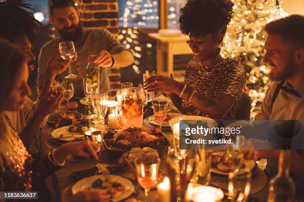 cozy new year dinner among friends - evening meal stock pictures, royalty-free photos & images
